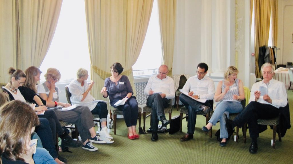 Photograph of participants seated in a semi-circle at the War to Peace® conflict resolution course